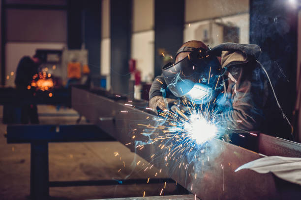 Skilled welder creating sparks while working on metal fabrication